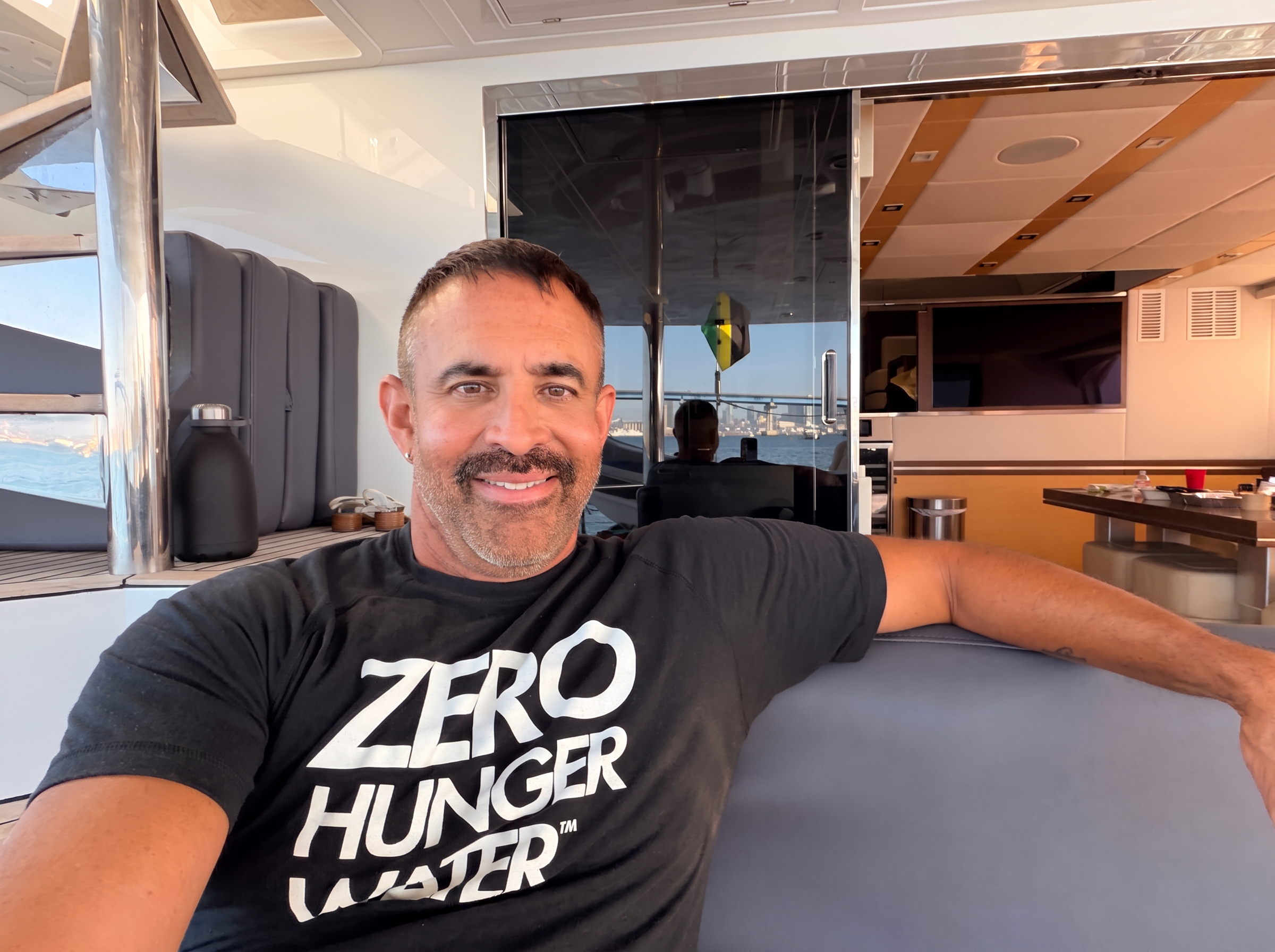 Jorge Cruise relaxing in his Zero Hunger Water t-shirt — ready to hear from you