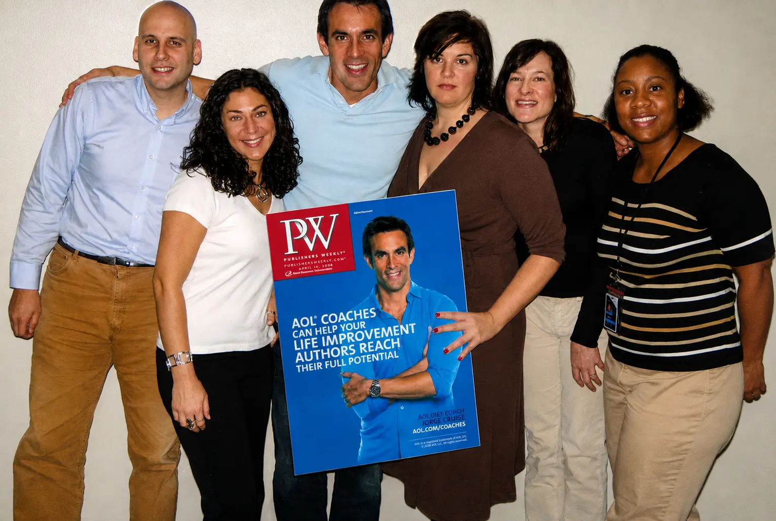 Jorge Cruise with the AOL Health team holding a poster of the Publishers Weekly AOL Coaches cover