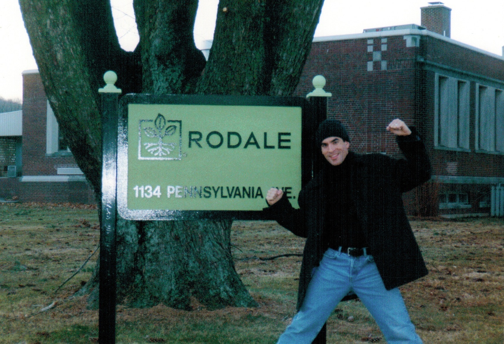 Jorge Cruise flexing beside the Rodale sign at 1134 Pennsylvania Ave., Emmaus, Pennsylvania